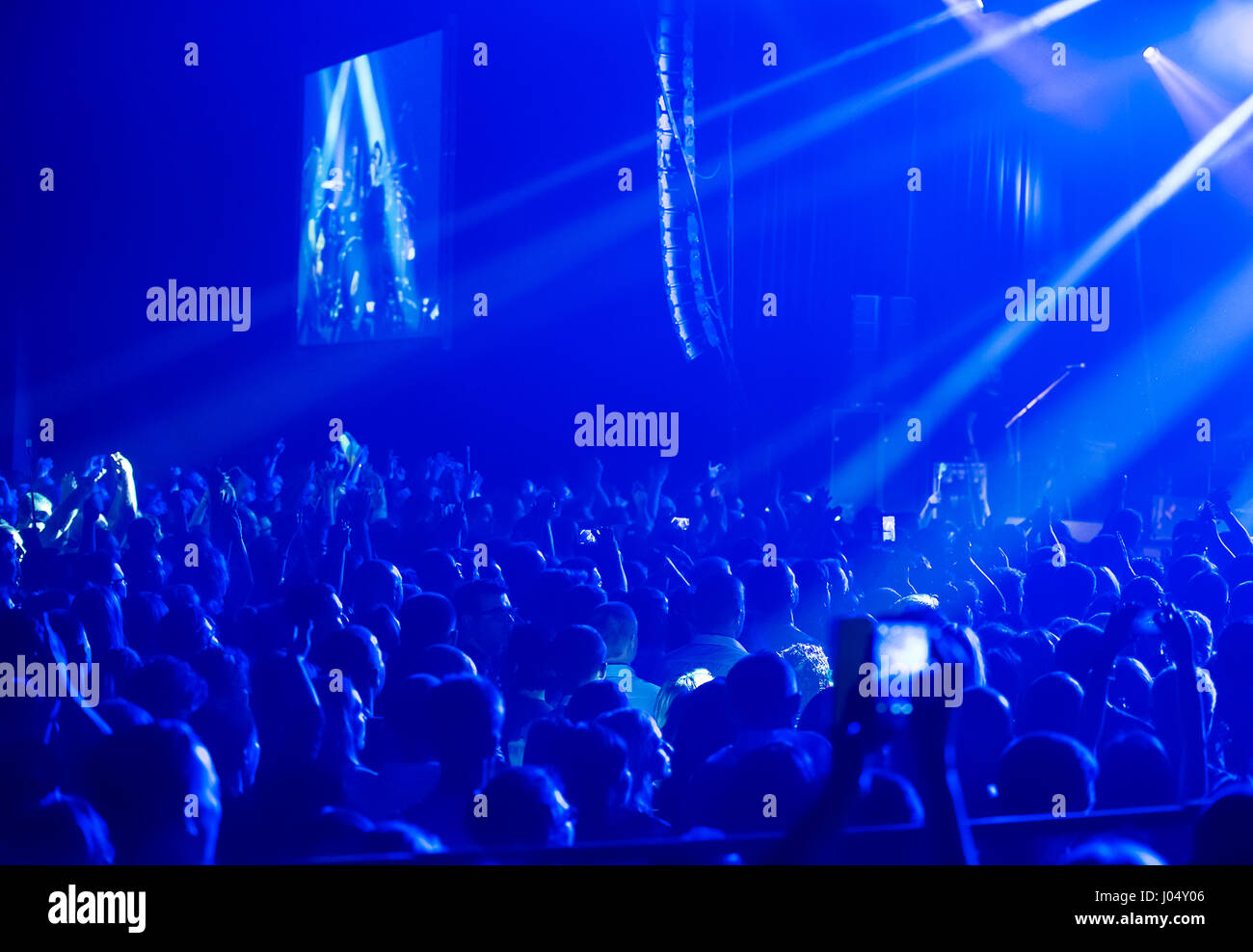 Crowd at concert and blurred stage lights . Close up of photographing with smartphone during a concert . Stock Photo