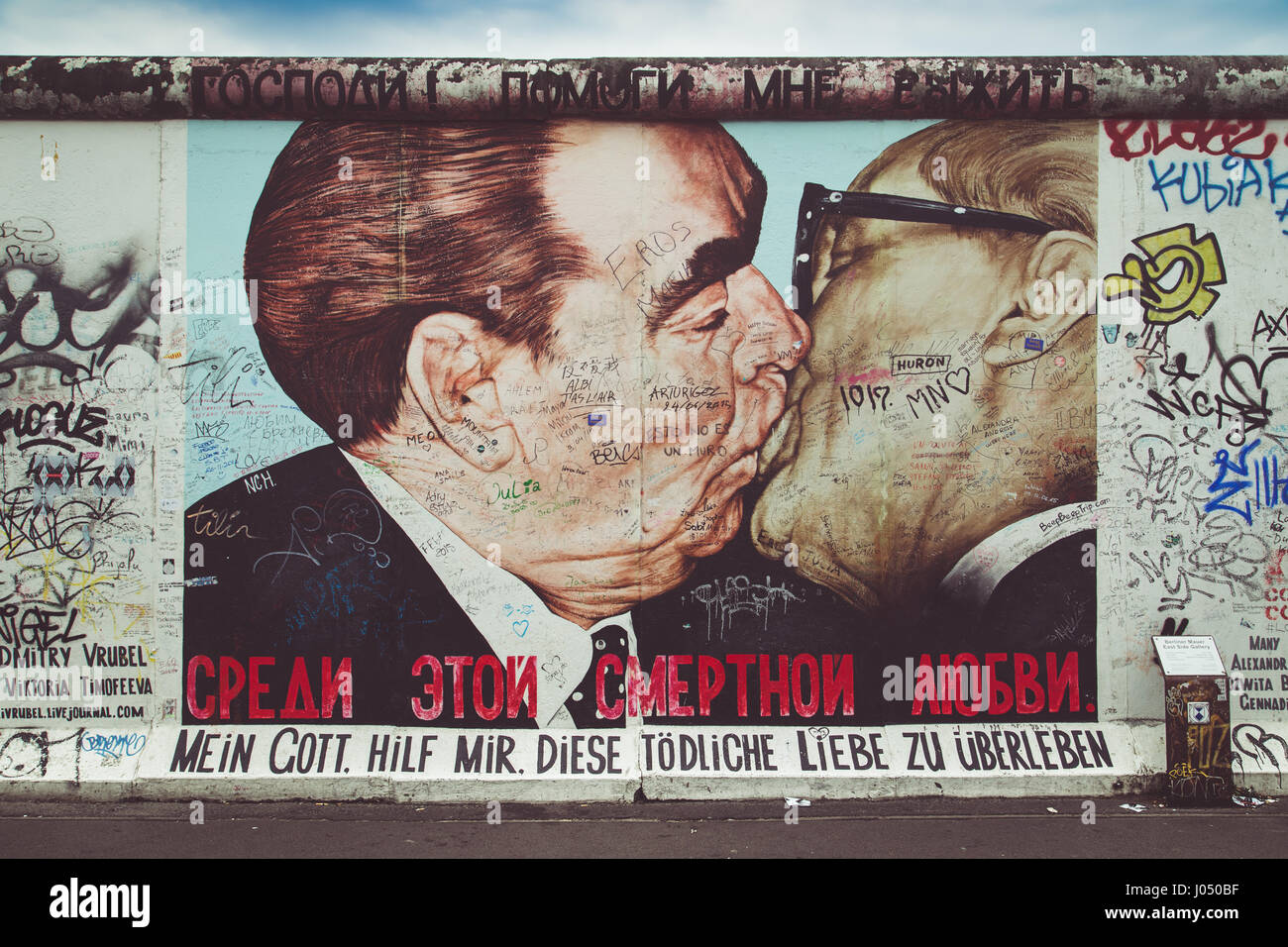 Street art graffiti painting 'The Kiss' by Dmitri Vrubel at famous East Side Gallery, the longest preserved section of Berlin Wall in central Berlin Stock Photo
