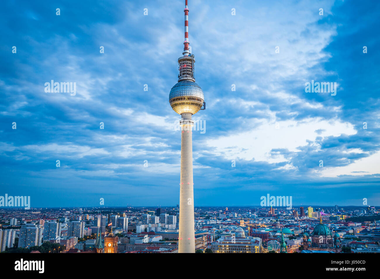 Aerial view of famous TV tower at Alexanderplatz with dramatic cloudscape in twilight during blue hour at dusk, Germany Stock Photo