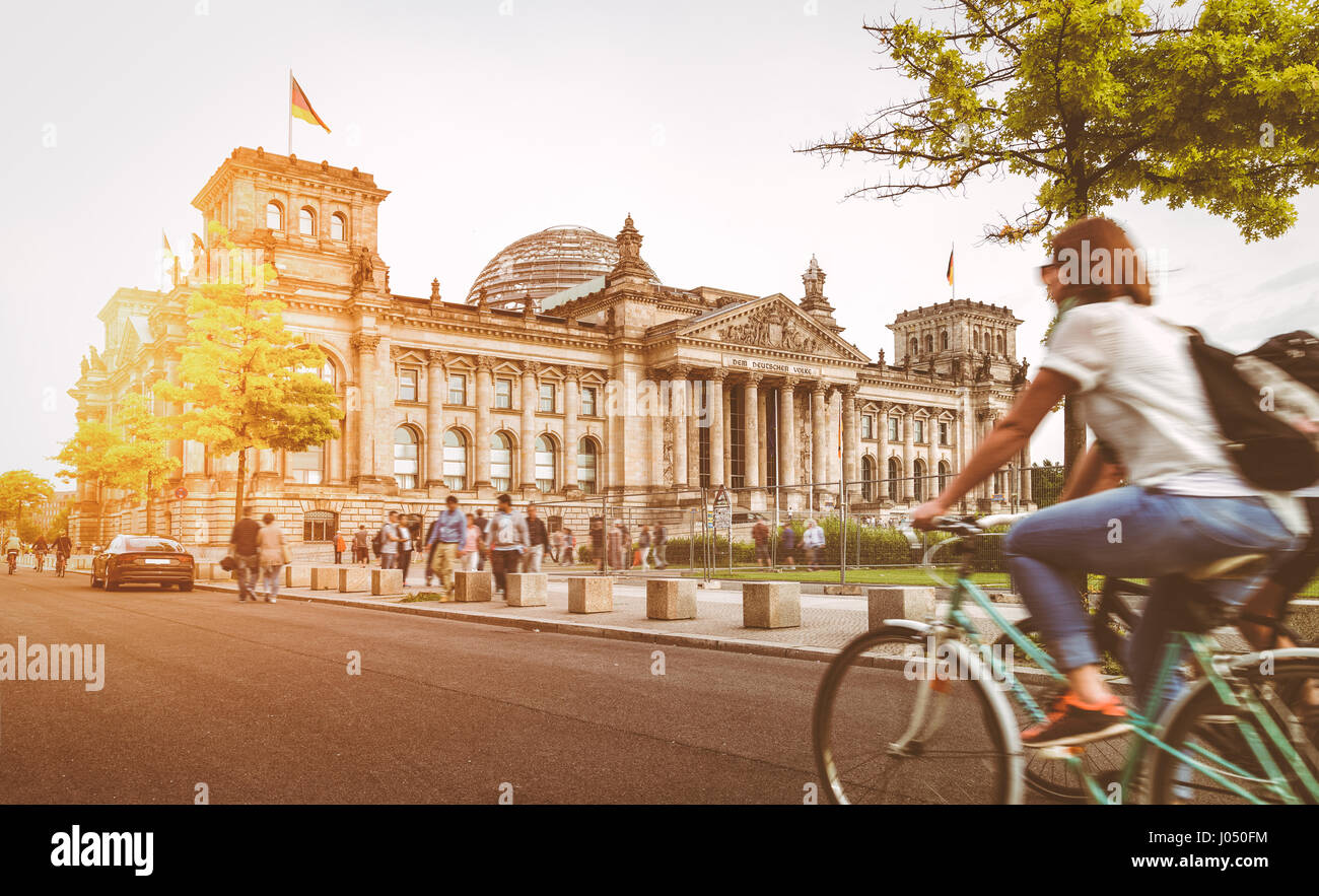Urban Berlin city life with famous Reichstag building in the background in beautiful golden evening light at sunset with retro vintage filter effect Stock Photo
