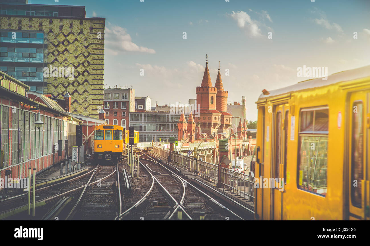 Panoramic view of Berliner U-Bahn with Oberbaum Bridge in the background in golden evening light at sunset with retro vintage filter effect, Berlin Stock Photo