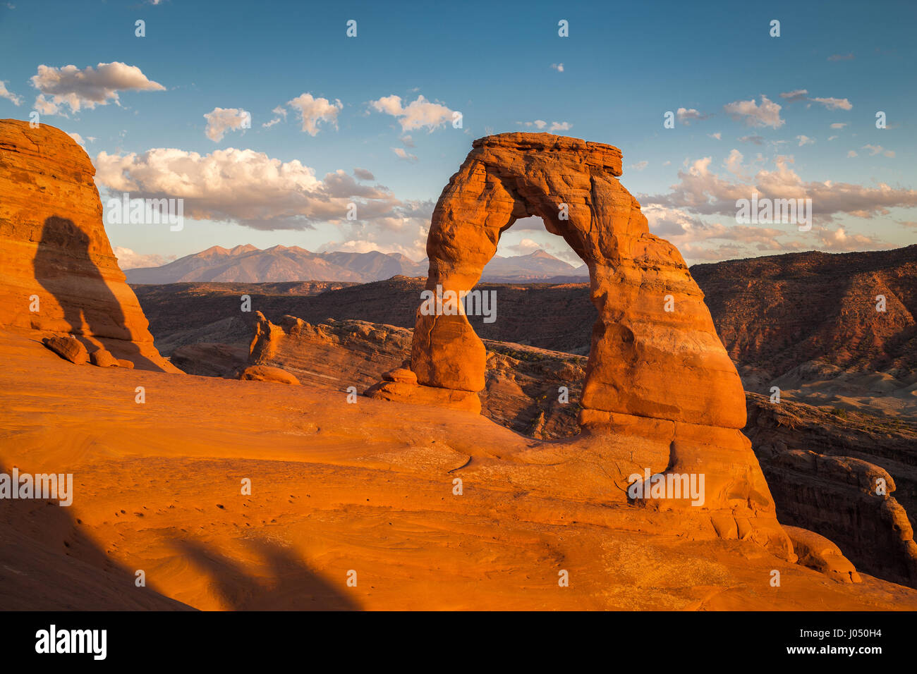 Classic postcard view of famous Delicate Arch, symbol of Utah and a popular scenic tourist attraction, in beautiful golden evening light at sunset Stock Photo