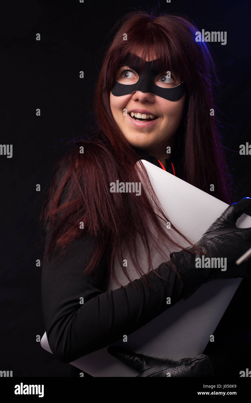Hacker in mask holds laptop Stock Photo - Alamy
