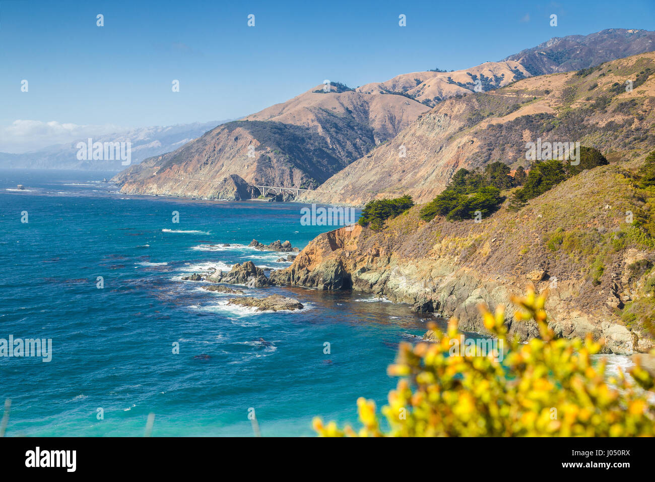 Scenic view of the rugged coastline of Big Sur with Santa Lucia Mountains and Big Creek Bridge along famous Highway 1 at sunset, California, USA Stock Photo