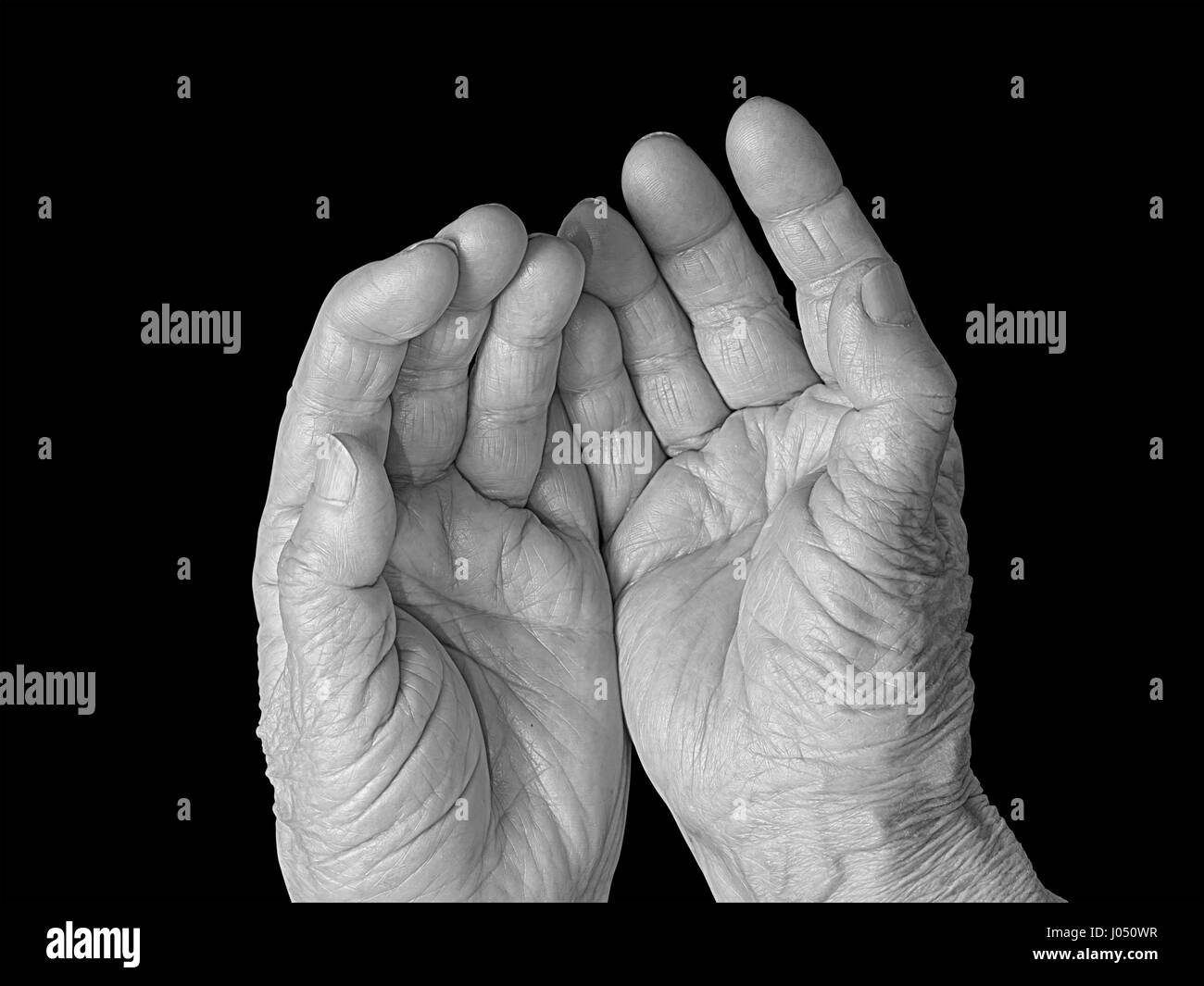 Senior woman outstretched hands, black and white photo. Isolated on black, clipping path included. Stock Photo