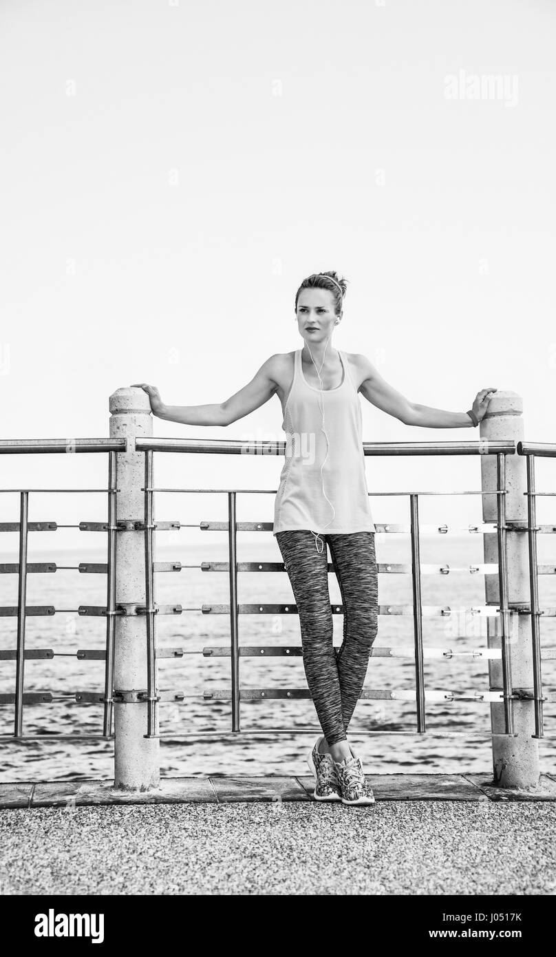 Look Good, Feel great! Full length portrait of young woman in fitness outfit looking aside at the embankment Stock Photo