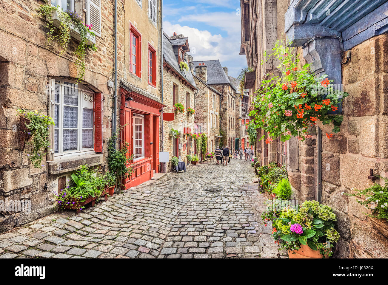 Beautiful view of scenic narrow alley with historic traditional houses and cobbled street in an old town in Europe with blue sky and clouds in summer  Stock Photo