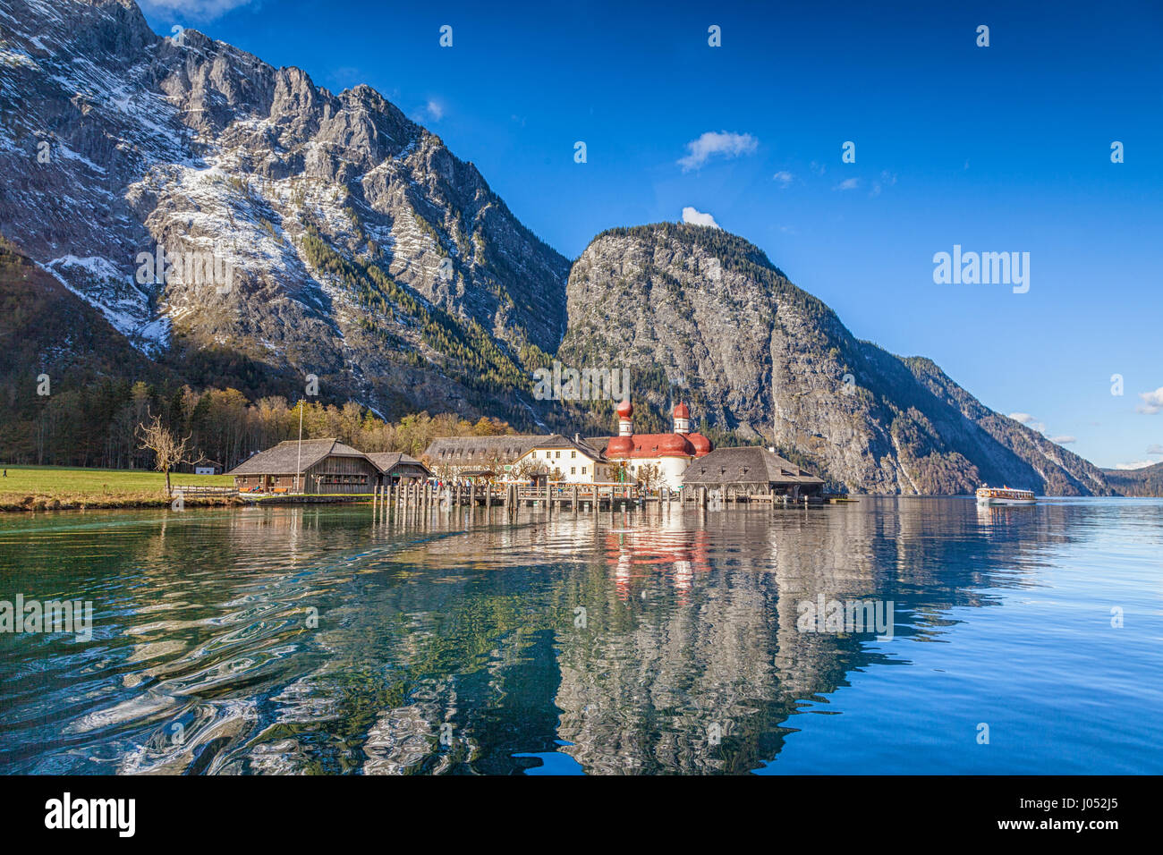 Beautiful view of scenic mountain scenery with Lake Konigssee with famous Sankt Bartholomae pilgrimage church and passenger ship, Nationalpark Berchte Stock Photo