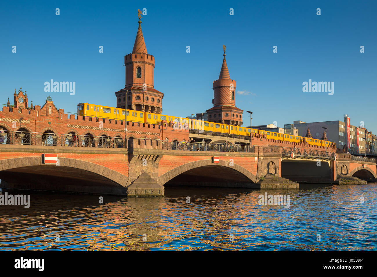 Classic panoramic view of famous Oberbaum Bridge with historic Berliner U-Bahn crossing the Spree river on a beautiful sunny day with blue sky, Berlin Stock Photo