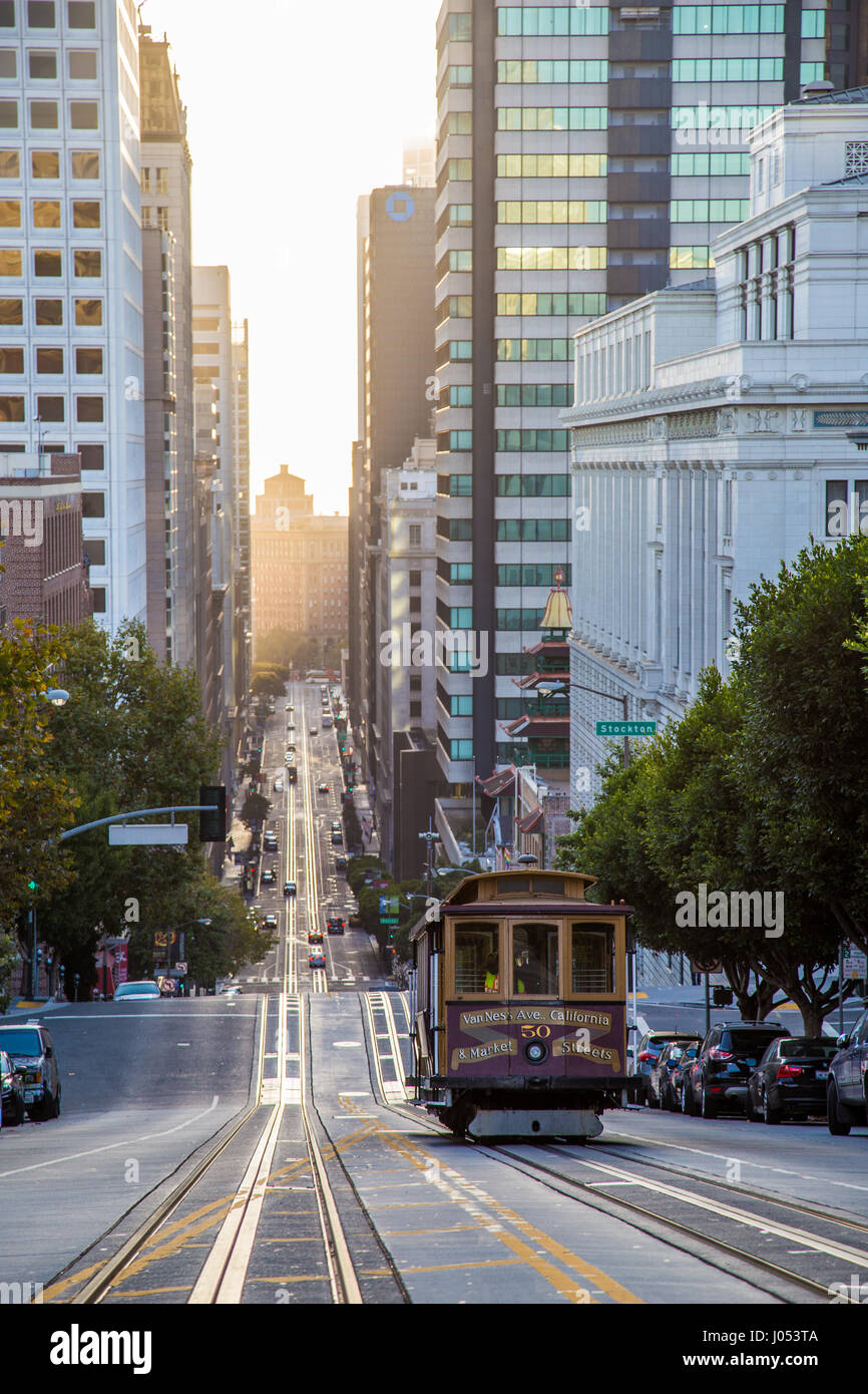 Classic view of historic Cable Car riding on famous California Street in beautiful golden morning light at sunrise in summer, San Francisco, USA Stock Photo