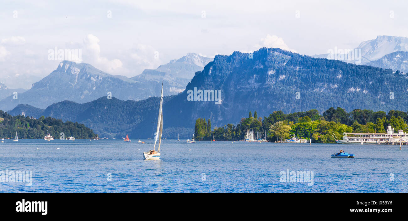 Scenic panoramic view of boats on idyllic Lake Lucerne with alpine mountain scenery in the background on a beautiful sunny day in summer, Switzerland Stock Photo