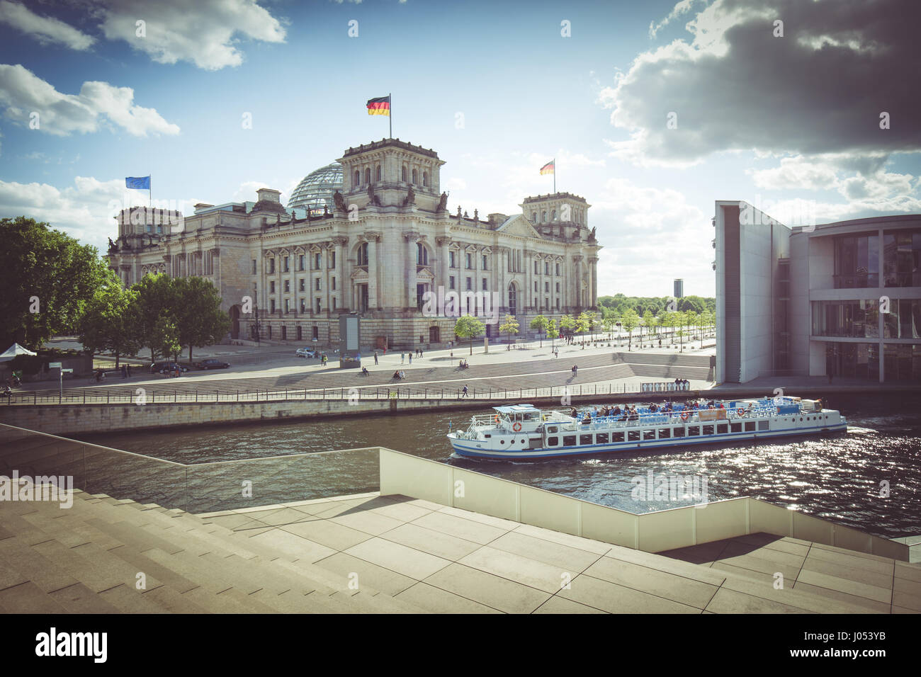 Panoramic view of Berlin government district with excursion boat on Spree river passing famous Reichstag building and Paul Lobe Haus on a sunny day Stock Photo