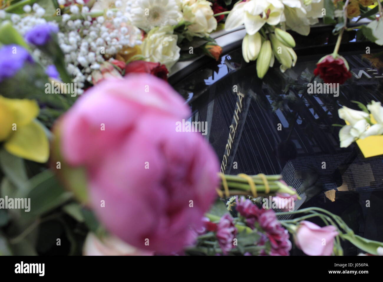 Reflection of the Ahlens shopping center building signage on a Swedish police (Polis) car glass window, covered with flowers, parked at 50 Drottninggatan street, marking the location of the last hit spot of the Stockholm attacker. on 7 April 2017. Stockholm, Sweden Stock Photo