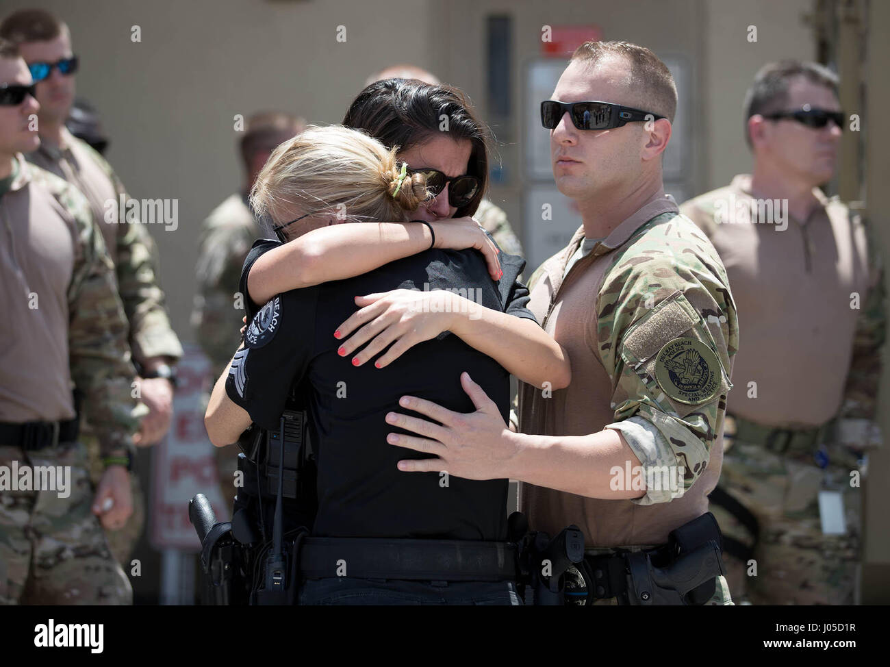 April 10, 2017 - Delray Beach, Florida, U.S. - Fellow officers hug Delray Beach Police Officer Stephanie Kearney (dark hair, dark glasses) after a press conference remembering Officer Christine Braswell, 40, who was killed in a scooter accident while off duty on vacation in Key West. Fellow officer Bernenda Marc, 25, was flown to Jackson Memorial South in Miami where she is recovering from critical injuries. (Credit Image: © Allen Eyestone/The Palm Beach Post via ZUMA Wire) Stock Photo