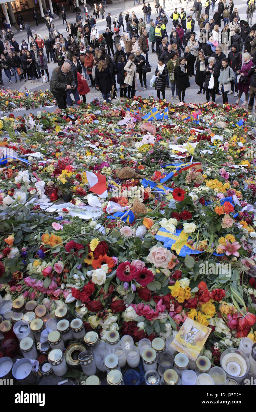 Stockholm, Sweden. 10th April, 2017. Gathered crowd mourning Stockholm terrorist attack at Sergels Torg square stairway, covered with pilled-up colurful flowers,  condolences, hope messages, Swedish flags and burning candles, expressing the nation's sympathy for the casualties  of the terrorist attack on 7 April 2017. Credit: BasilT/Alamy Live News Stock Photo