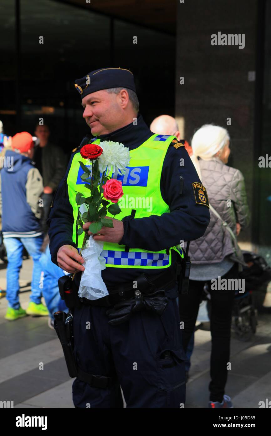 Emotional scenes at the site of the Stockholm Truck Attack. People have come to lay flowers on a police car on the Sunday after the attack. Stock Photo