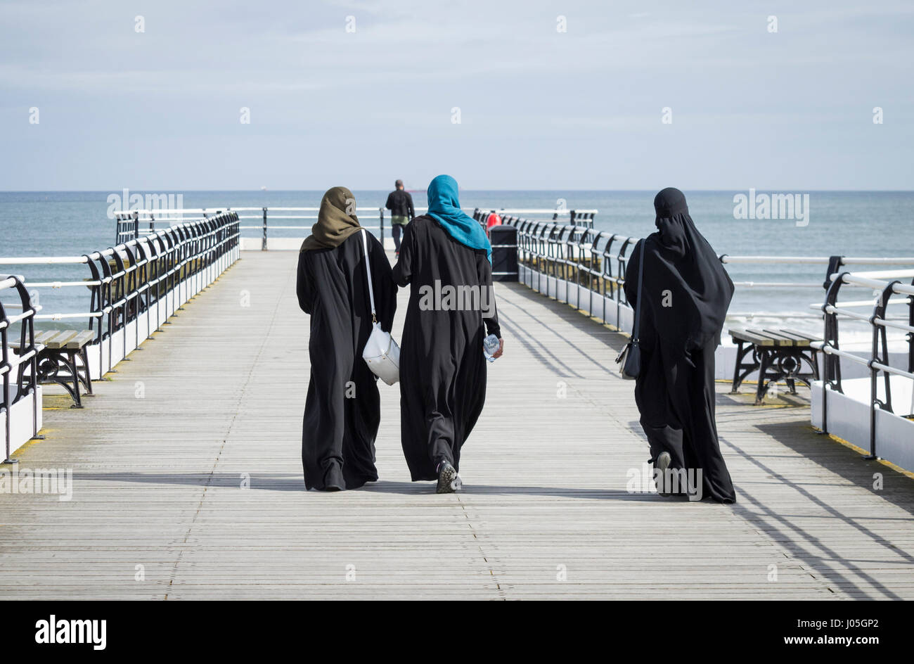Young Muslim women wearing Hijab headscarf on Saltburn pier. Saltburn by the sea, North Yorkshire, UK. Stock Photo