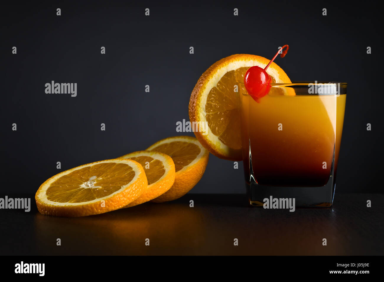 Cocktail "Tequila sunrise" garnished with orange slice and sweet cherry