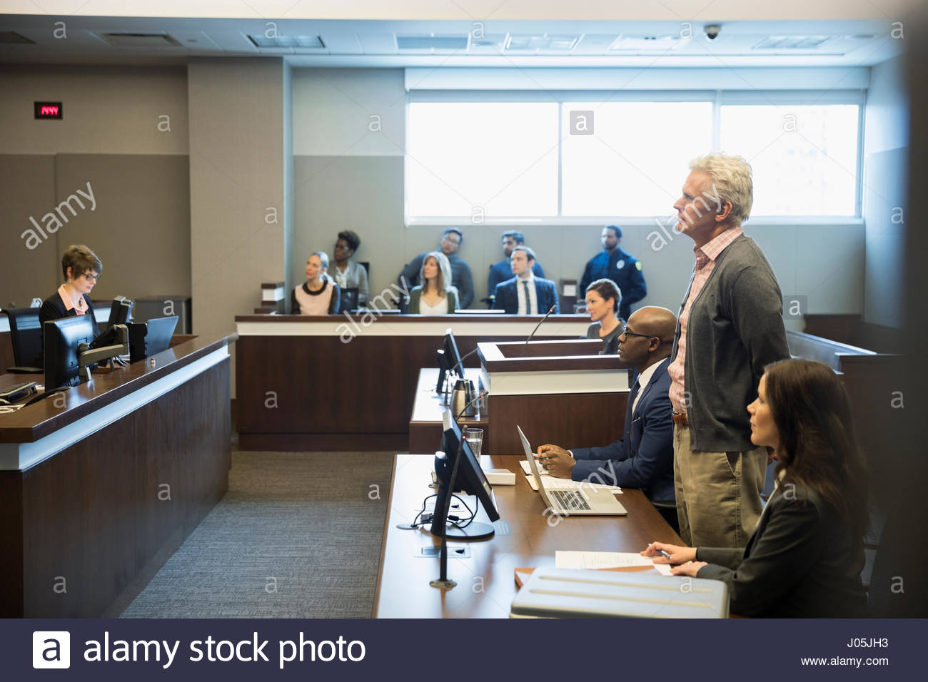 Defendant standing in legal trial courtroom Stock Photo
