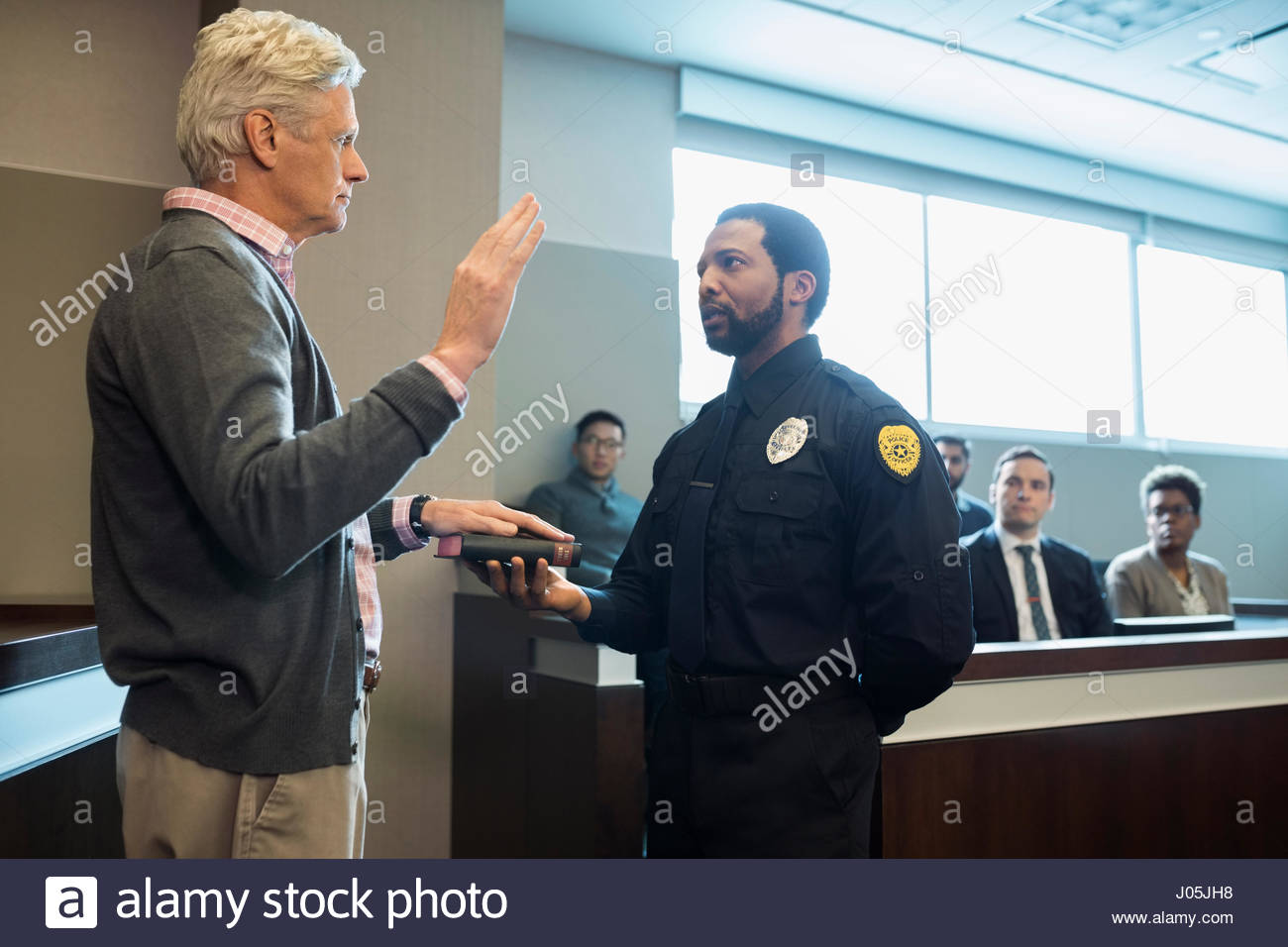 Male bailiff holding bible for witness in legal trial courtroom Stock Photo Alamy