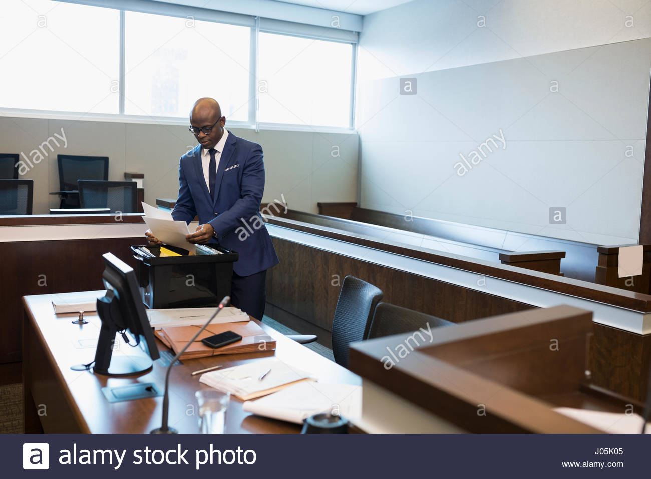 Male prosecutor attorney reviewing paperwork in courtroom Stock Photo