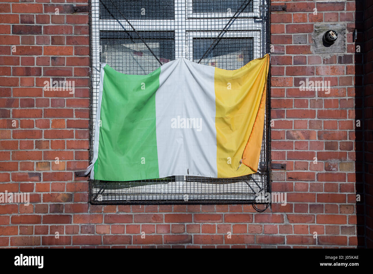 An Irish flag hanging in a window. Stock Photo