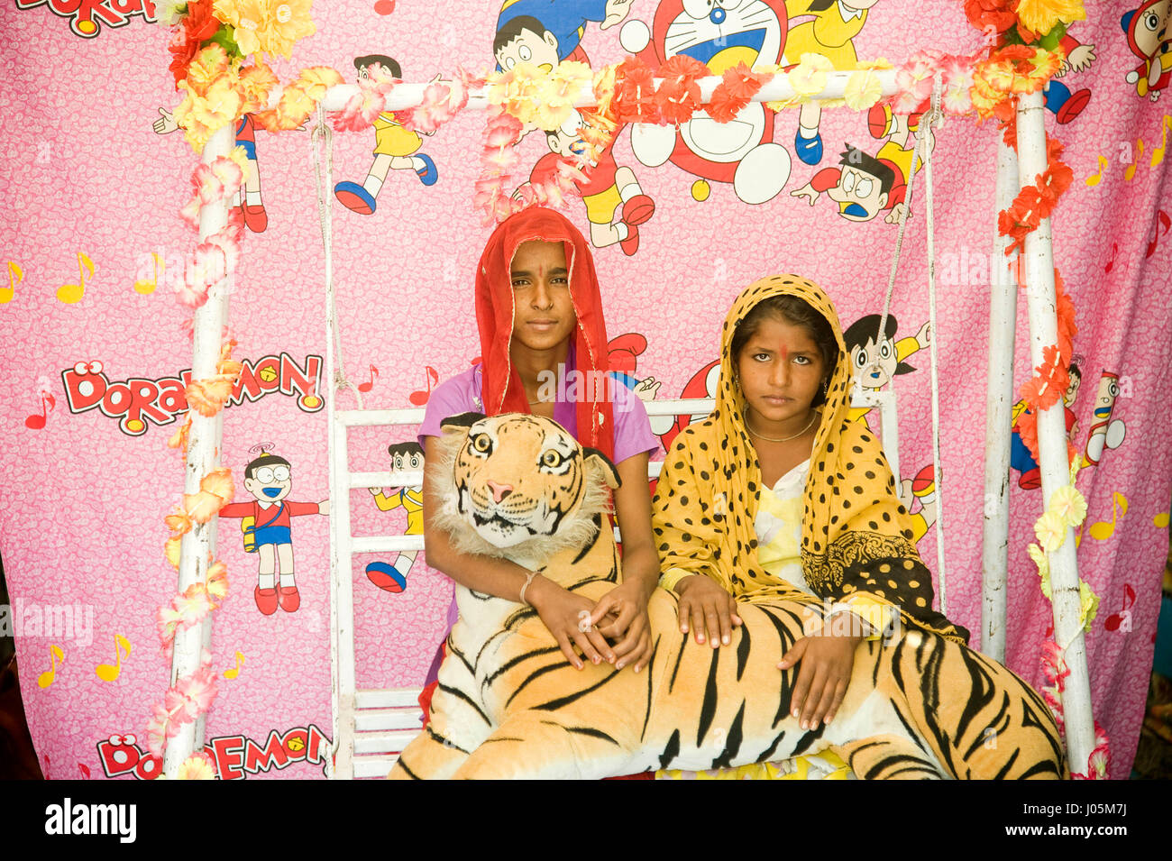Girls sitting posing with stuffed tiger, pushkar fair, rajasthan, india, asia Stock Photo
