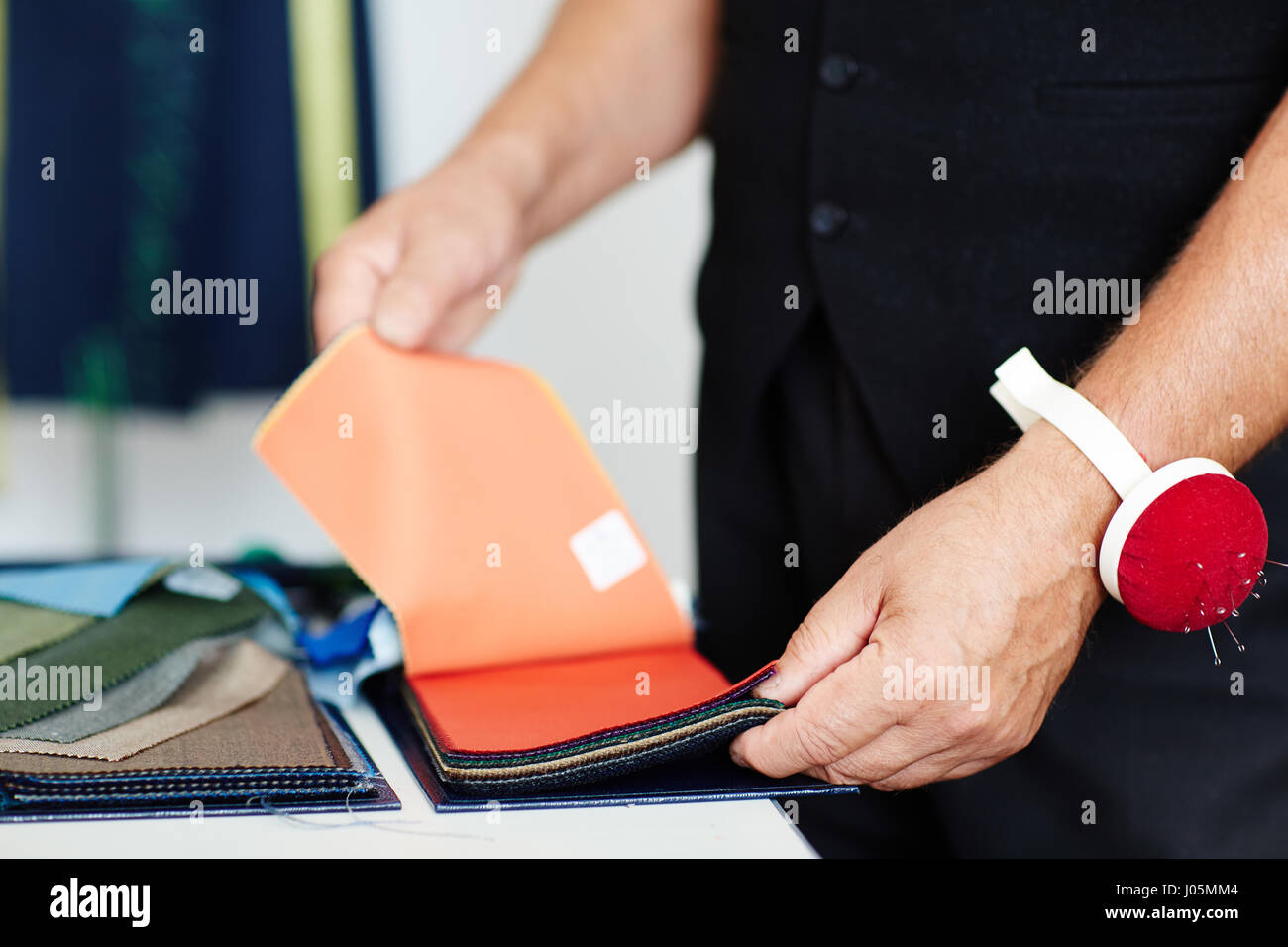 Tailor choosing fabric samples for client Stock Photo - Alamy