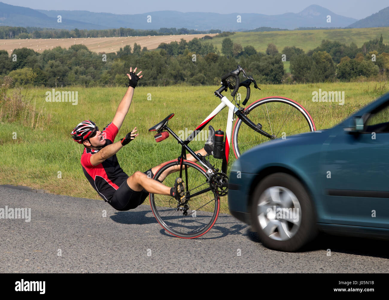 Accident cars with biker. Car collides cyclist on the road. Dangerous traffic on asphalt way on the countryside. Stock Photo