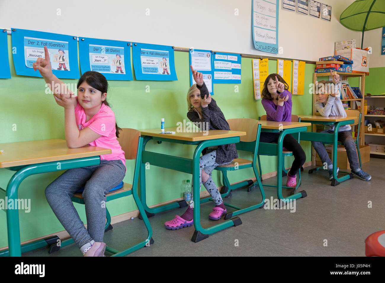 pupils at primary school raising their hands, Lower Saxony, Germany Stock Photo