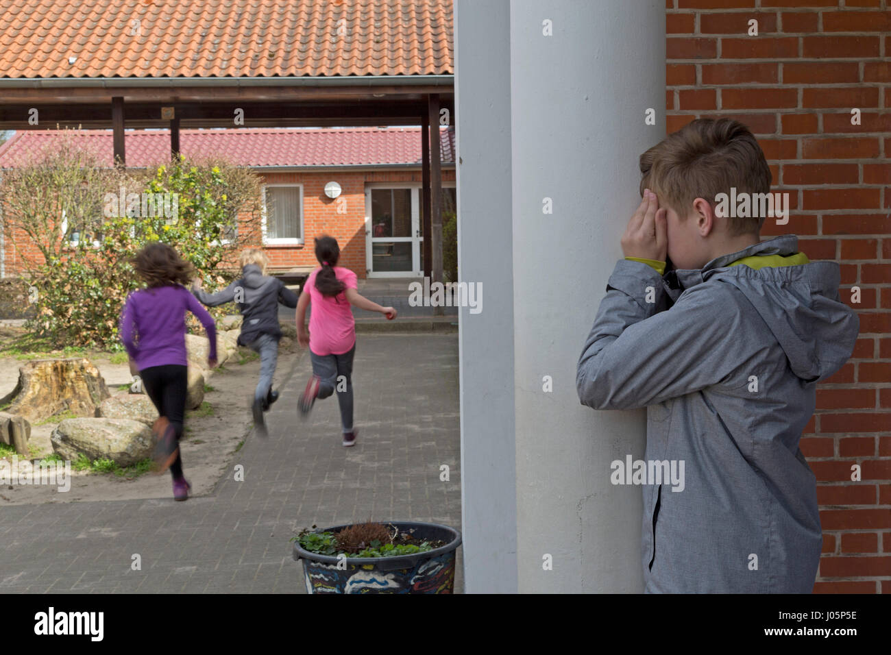 pupils at primary school playing hide and seek during break, Lower Saxony, Germany Stock Photo