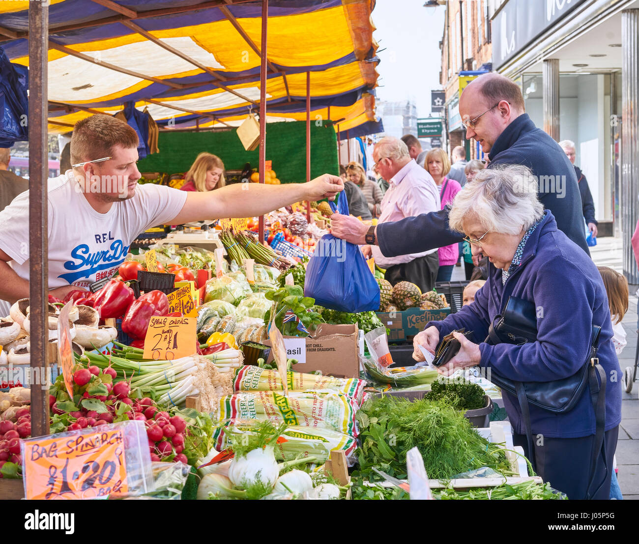 Shoppers buy vegetables from St Albans market. Stock Photo