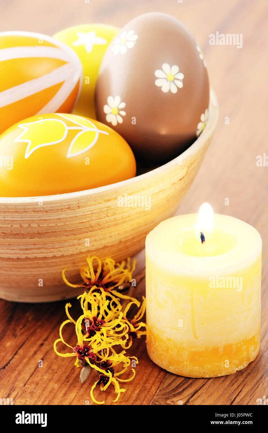 Orange easter eggs in a cup with american witchhazel twig and candle Stock Photo Alamy