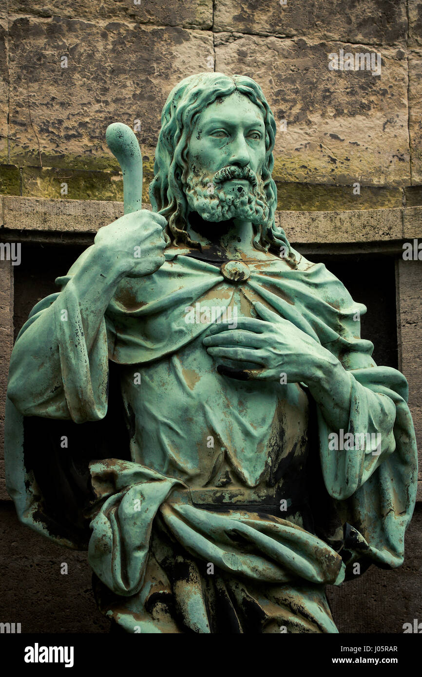 old weathered and with verdigris coated Jesus Sculpture at a Graveyard