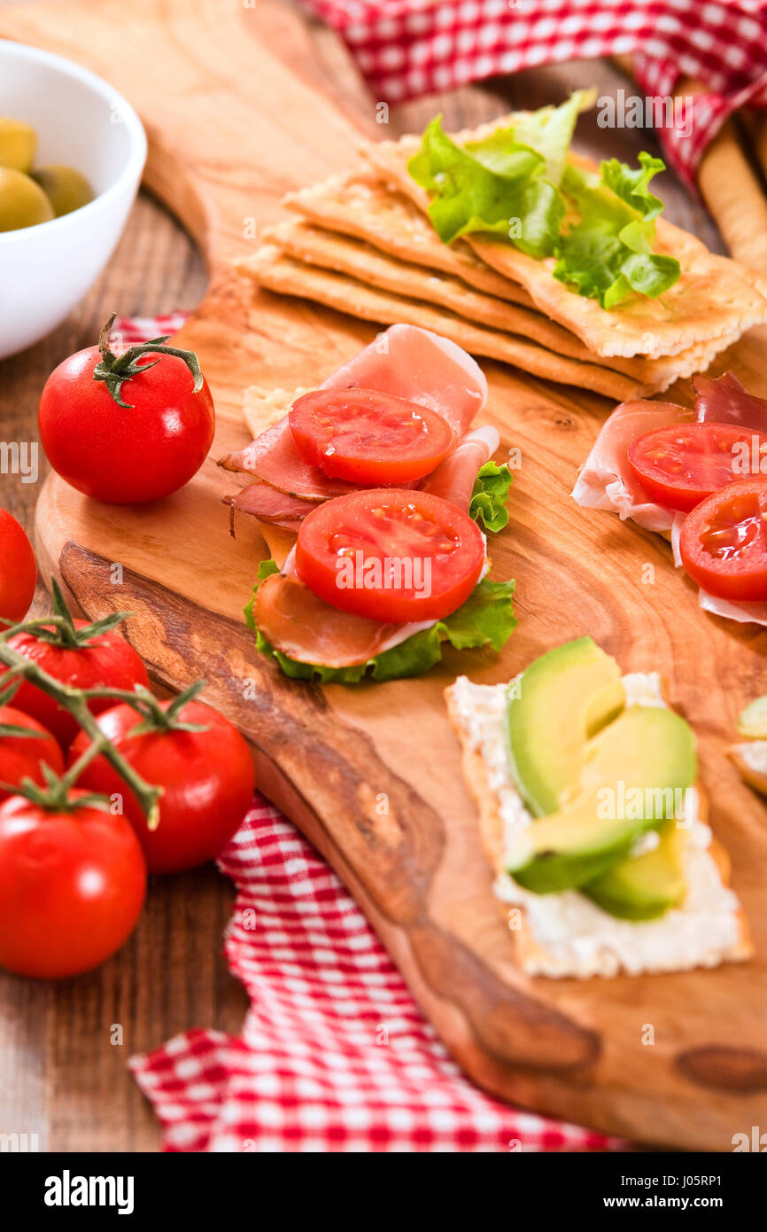 Crackers with ham and avocado Stock Photo Alamy