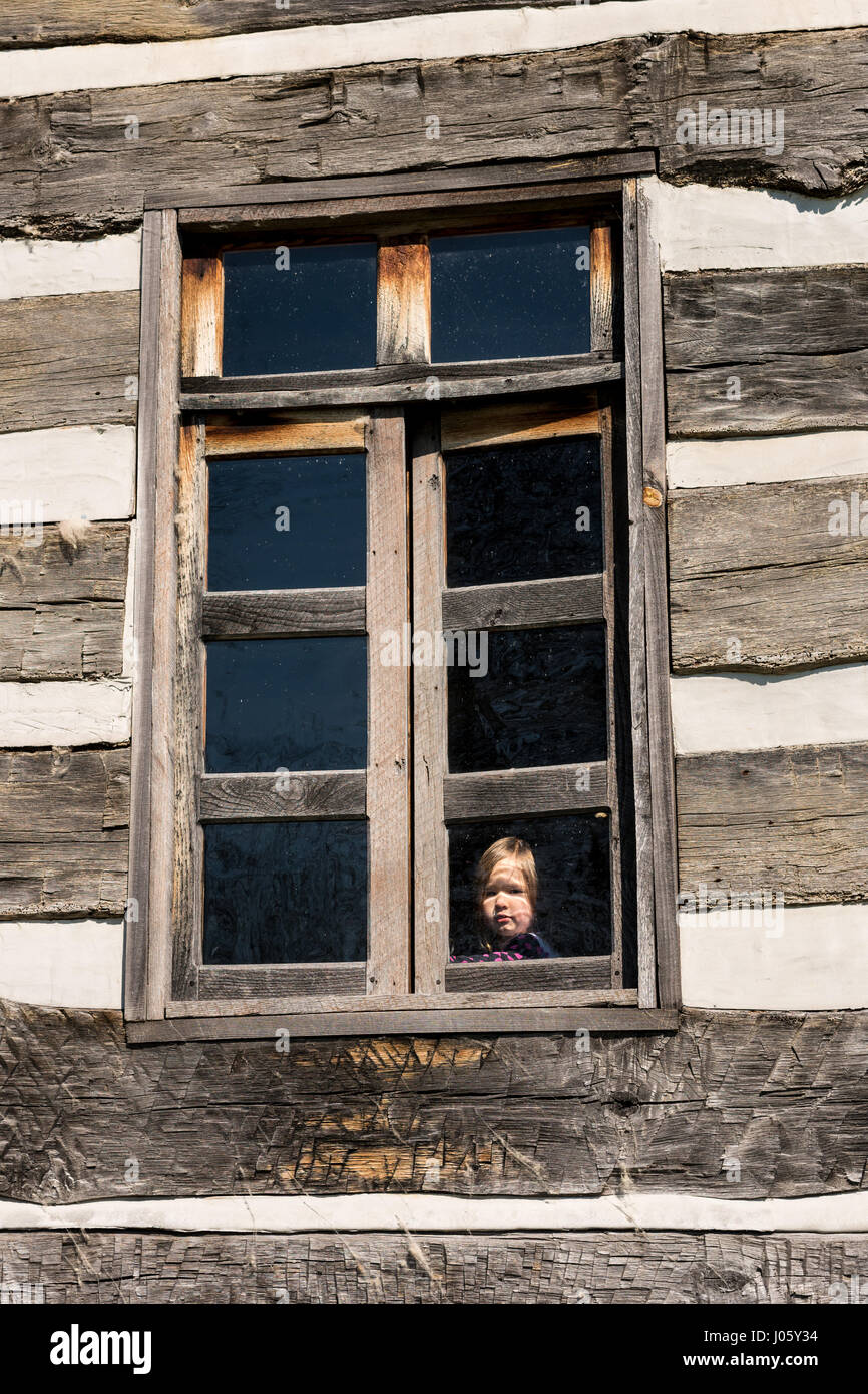 Lonely small baby girl behind window Stock Photo