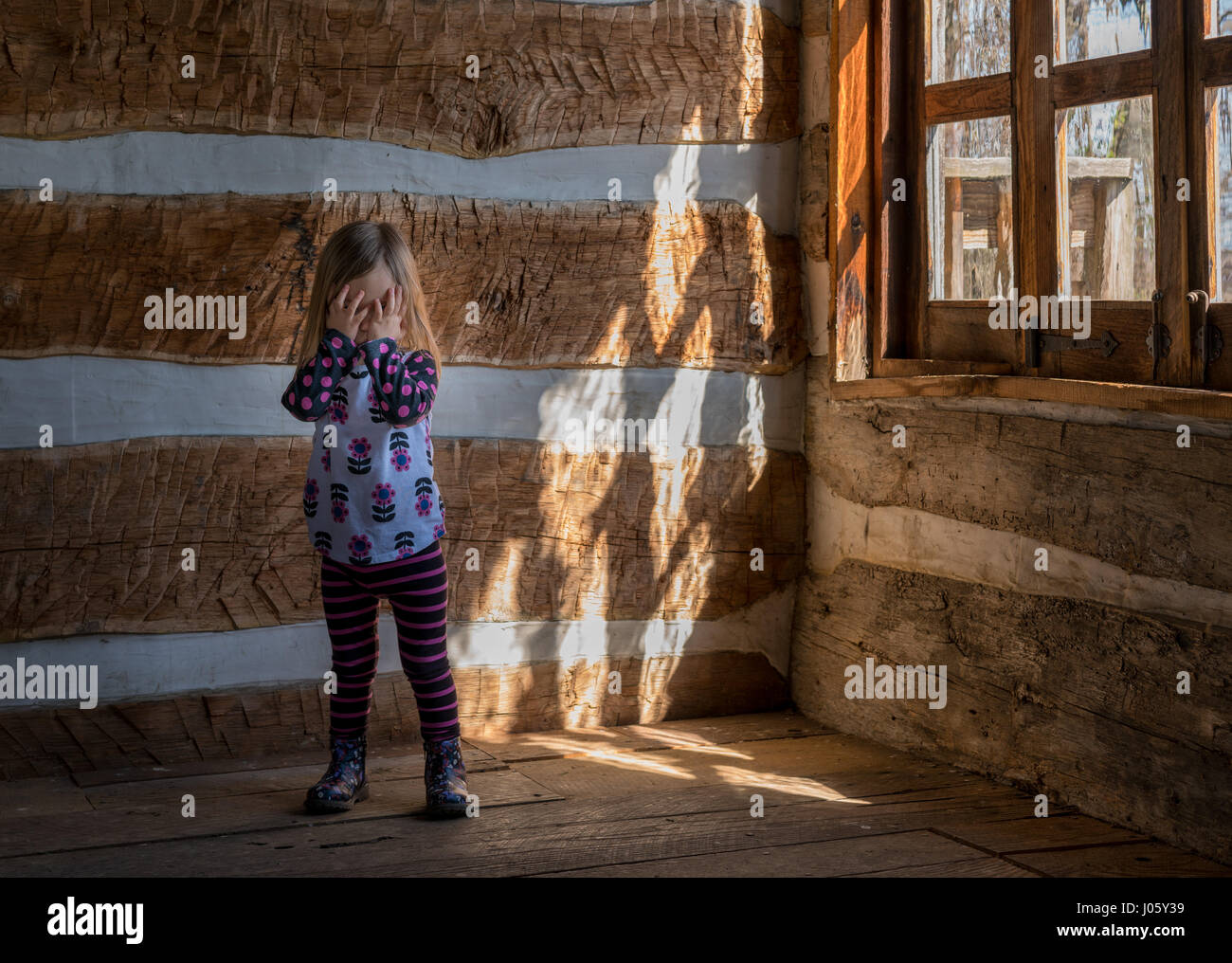 Lonely small baby girl in empty cabin Stock Photo