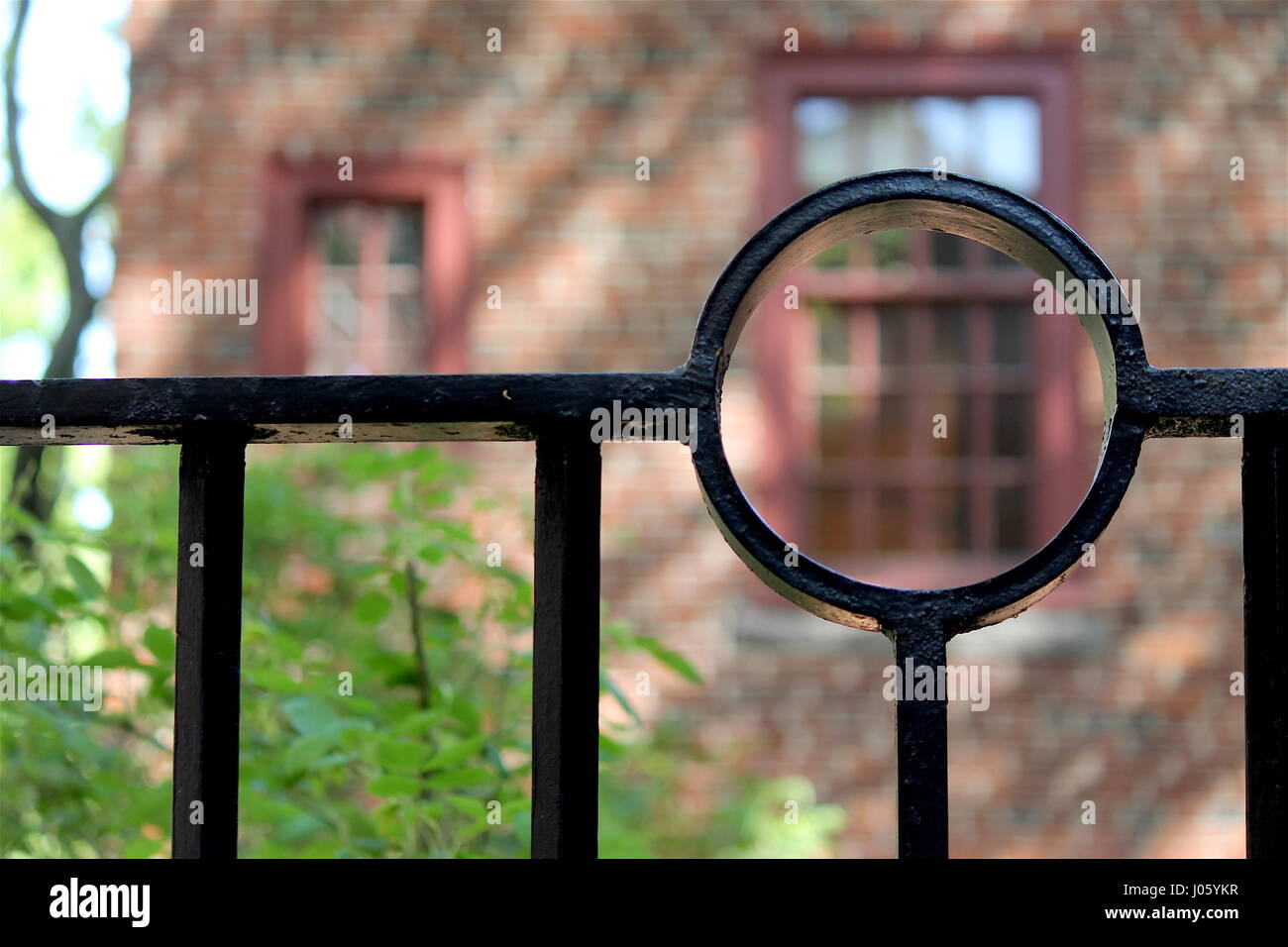 Black Iron Fence with Red Brick in Background Stock Photo