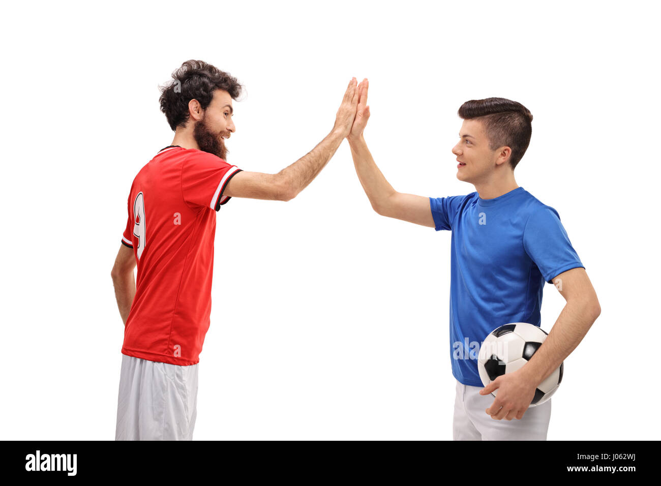 Father and son dressed in sport jerseys high fiving each other isolated on white background Stock Photo
