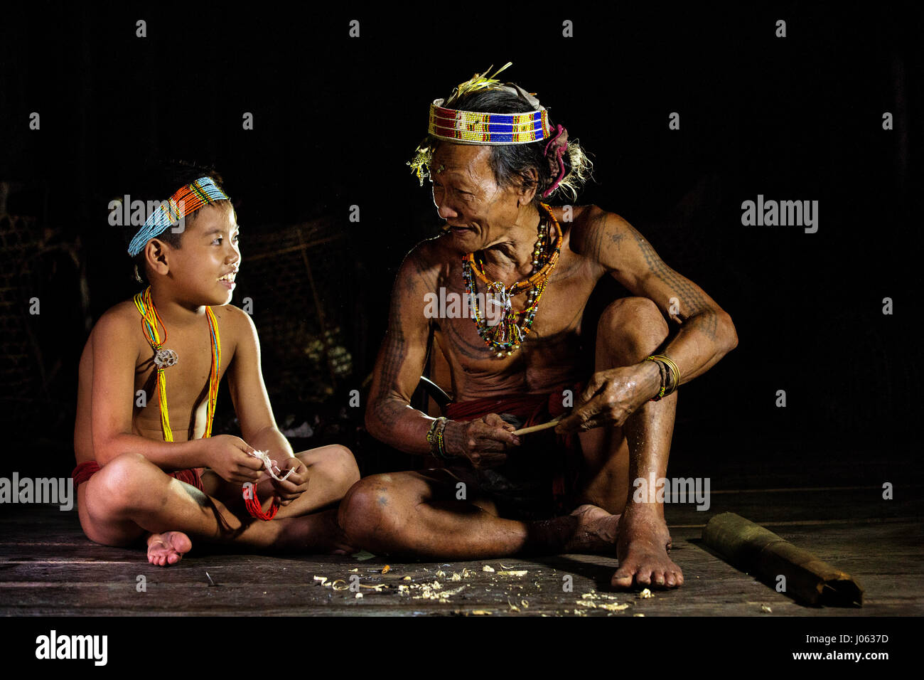 SIBERUT ISLAND, INDONESIA: MAGNIFICENT photographs of the last members of a tattooed tribe give an insight into their daily lives on the isolated island they call home. The Mentawai Tribe live a basic and traditional lifestyle away from the technology of the 21st Century. The photographs show the tribe hunting in vast tropical jungle and captured personal moments as a father handed down tribal traditions to his son. These people are the last to use their tribal technique of hand-tapping to tattoo their bodies. They inhabit Siberut Island in Indonesia and were intimately photographed by Henry K Stock Photo