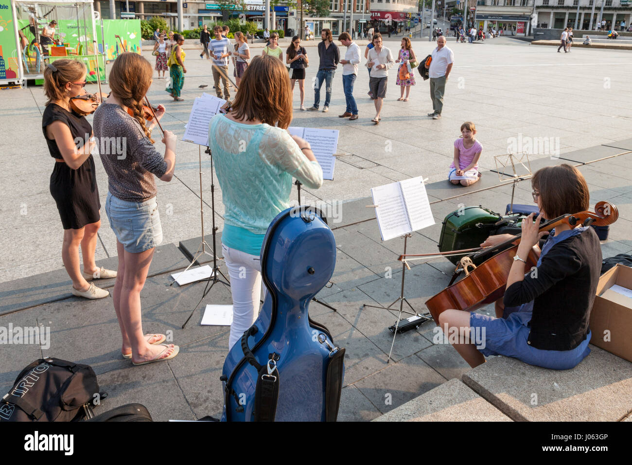 Musicians busking: Young women buskers playing classical string quartet ...
