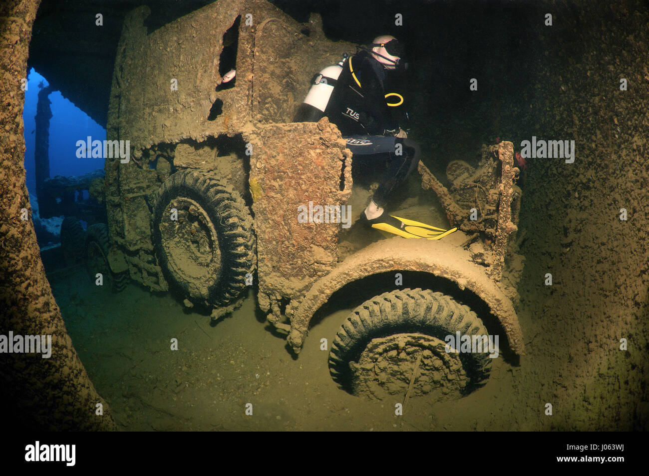One diver sits on a truck recreating what might have been. EERIE underwater pictures show inside the wreckage of the sunken British World War Two ship SS Thistlegorm on the seventy-fifth anniversary of her sinking. The series of images show the rusted remains of the merchant navy ship’s cargo which includes motorbikes, army trucks and an aircraft propeller. Other pictures show how sea life have been inhabiting the wreckage. Stock Photo