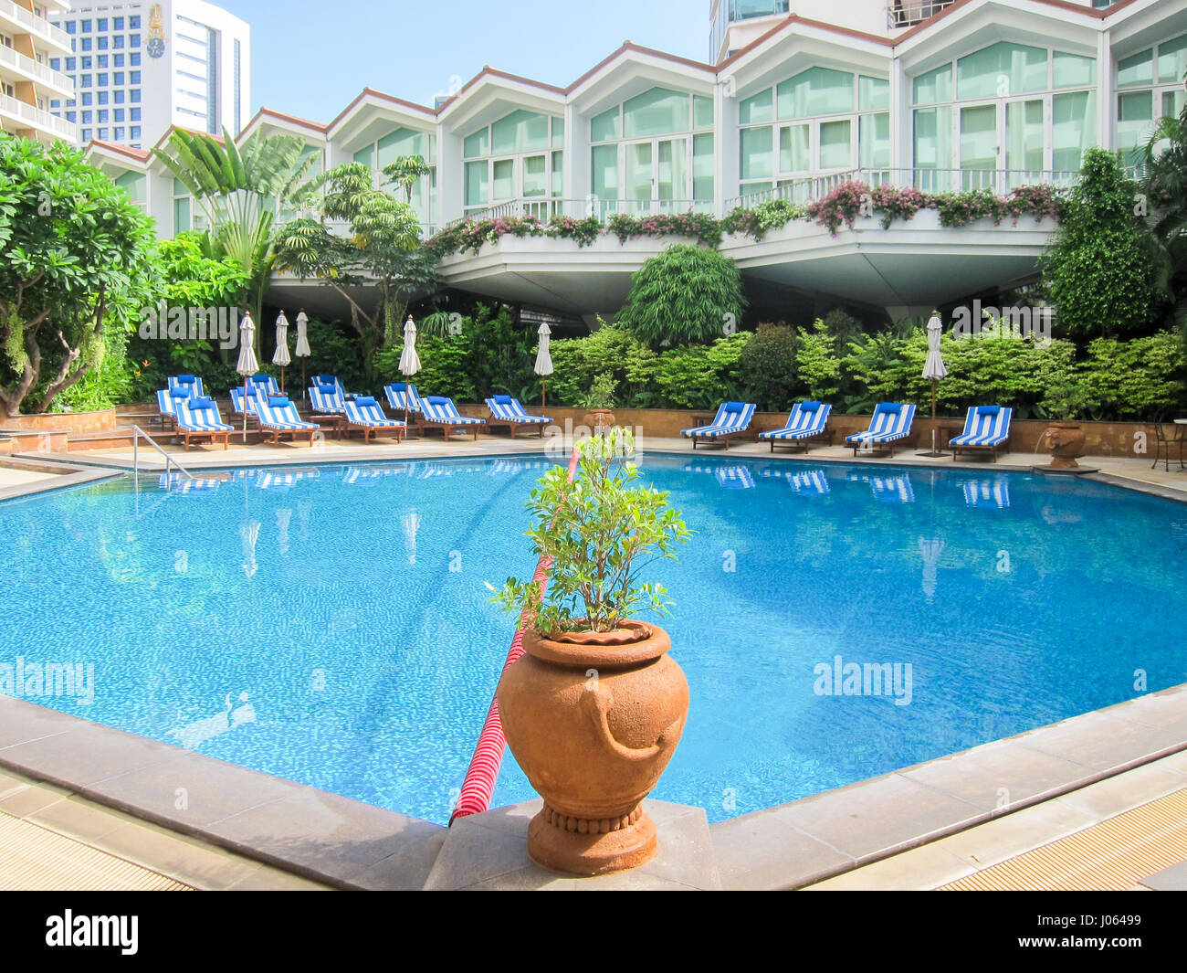 Swimming pool of the Dusit Thani five star hotel with sunbeds in Bangkok, Thailand Stock Photo