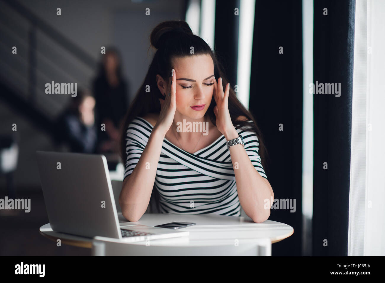 Tired minded woman thinking about way to complete a task. Beatiful female having a headache during a break in a cafe. Stock Photo