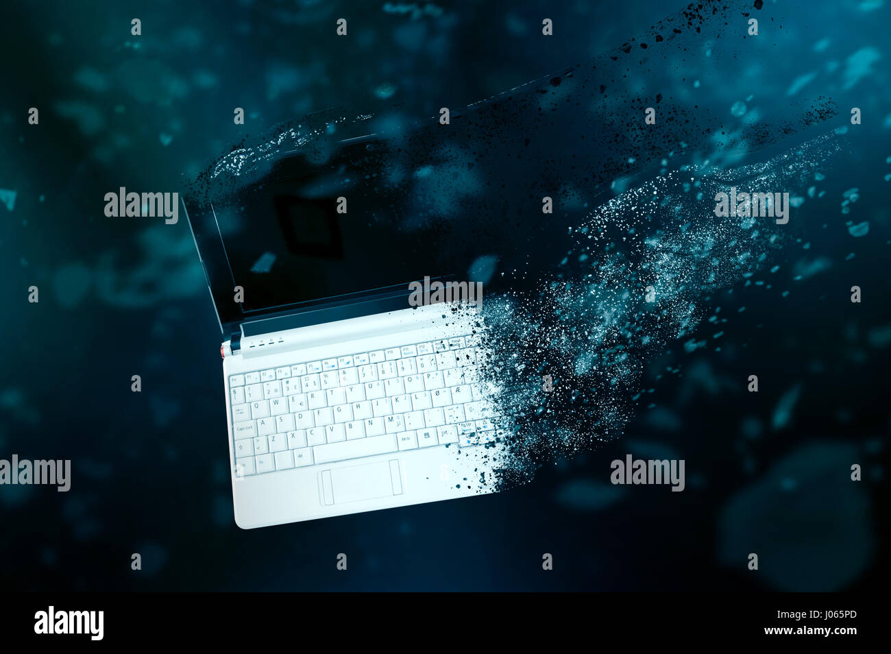 The old laptop is disintegrating in space. Conception of passage of time and obsolete technology Stock Photo
