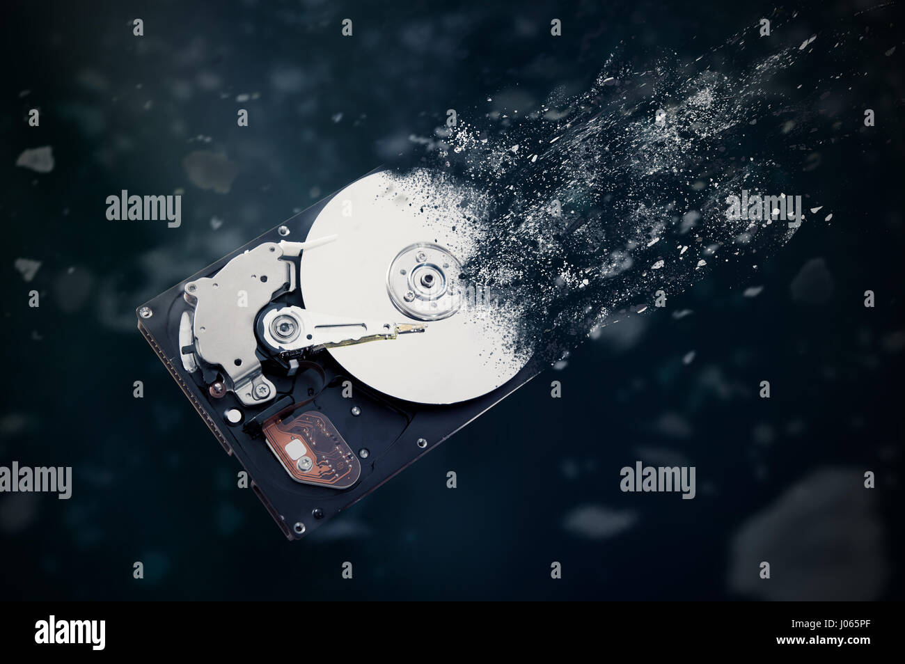 The old hard disk drive is disintegrating in space. Conception of passage of time and obsolete technology Stock Photo