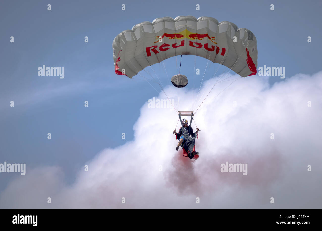An sportsman sponsored by Red Bull does paragliding with attached smoke flares Stock Photo - Alamy