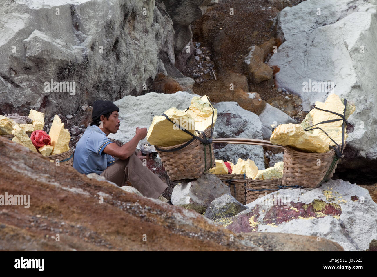 Workers Carrying Rocks A man takes a break from carrying his heavy load of sulphur rocks ...