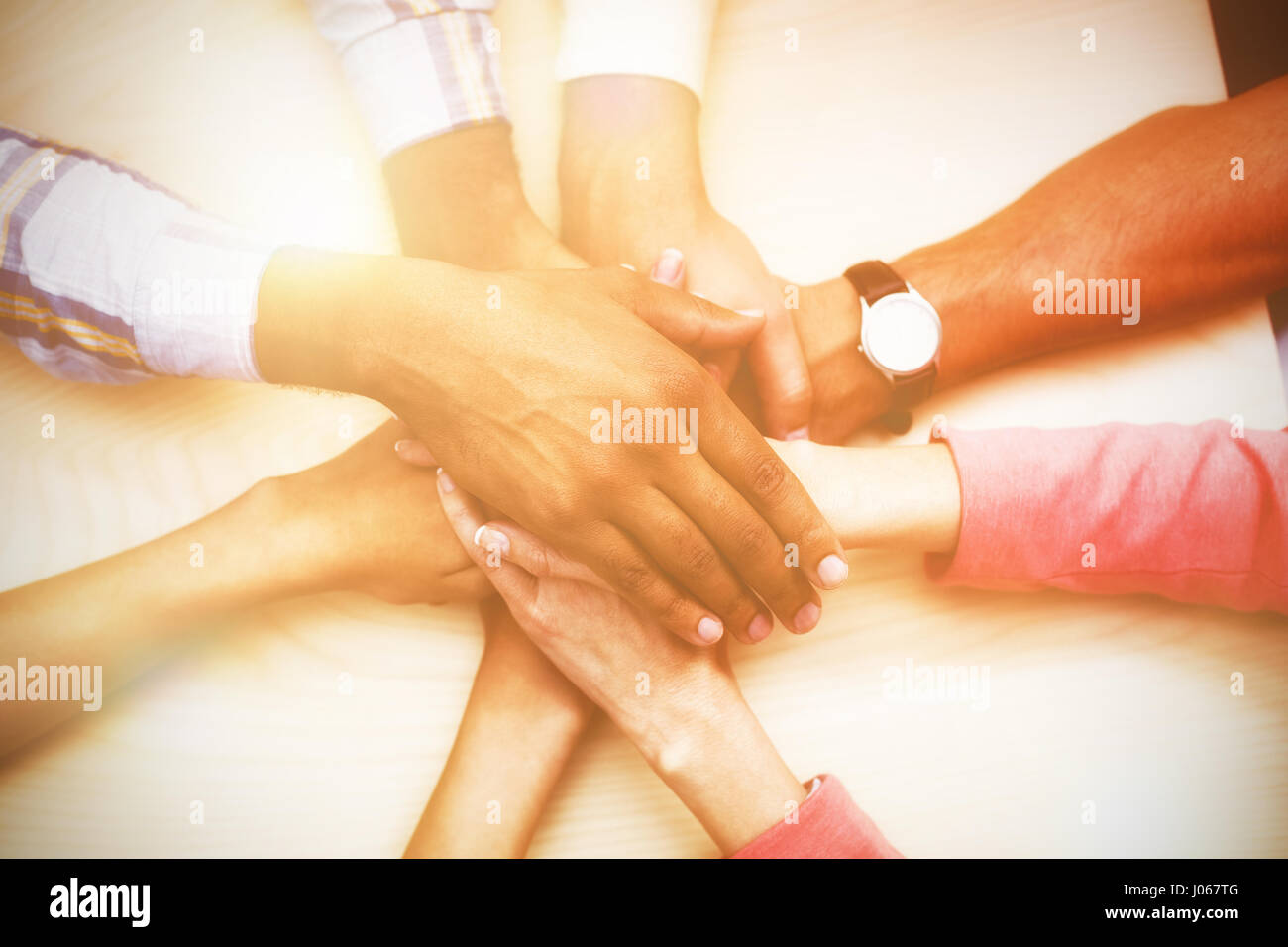 Overhead view of business people stacking hand at table Stock Photo