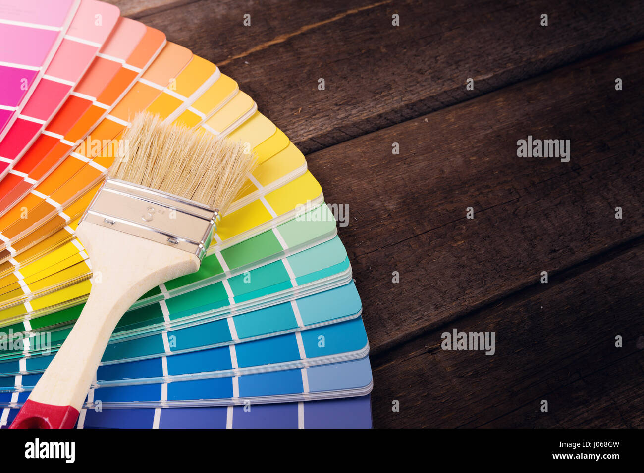 paintbrush on colorful paint swatches with copy space Stock Photo